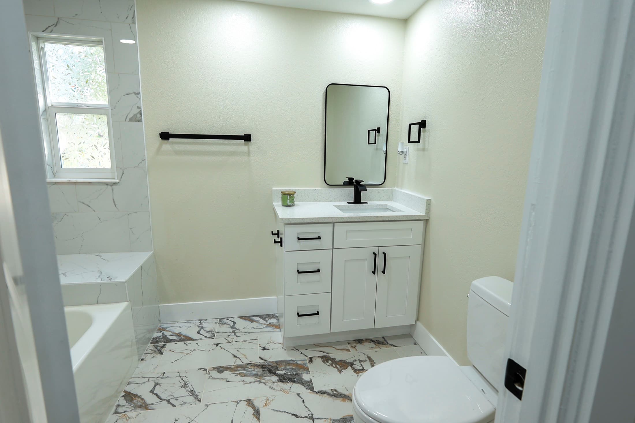 Renovated bathroom with marble tile and black fixtures